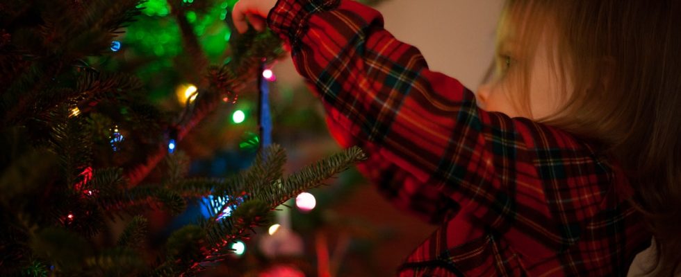 Enfant qui décore un sapin