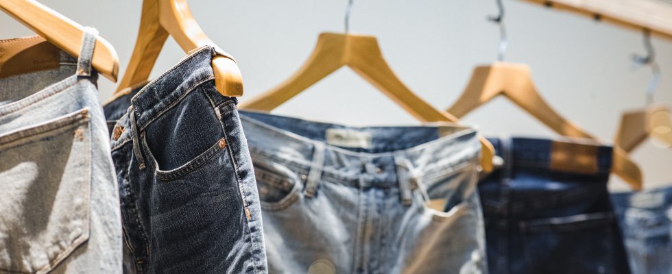 jeans suspendus à des cintres