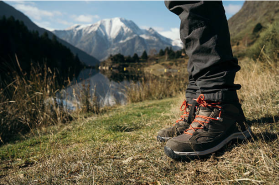 vue sur les pied d'une personne à la montagne portant des chaussures de randonnée