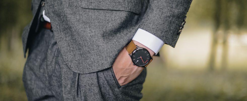 Homme en costume chic qui porte une montre de luxe